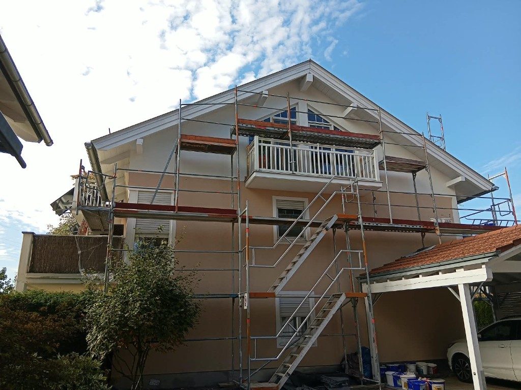 Apricotfarbene Fassade im Gerüst, Anstrich noch im Gang