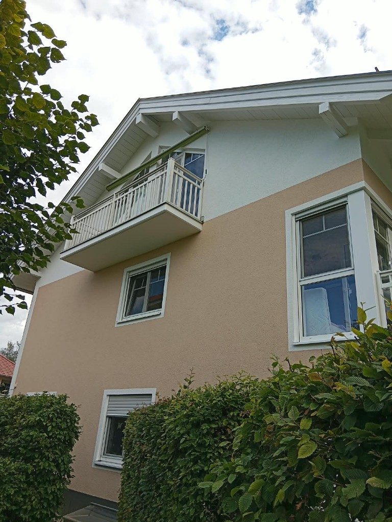 Fertige Fassade in Apricot und Weiß mit weißem Balkon