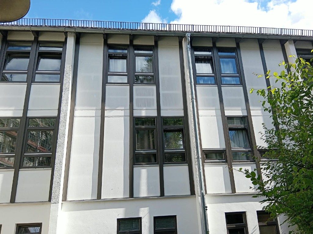 Helle Fassadenflächen zwischen dunklen Fensterbändern