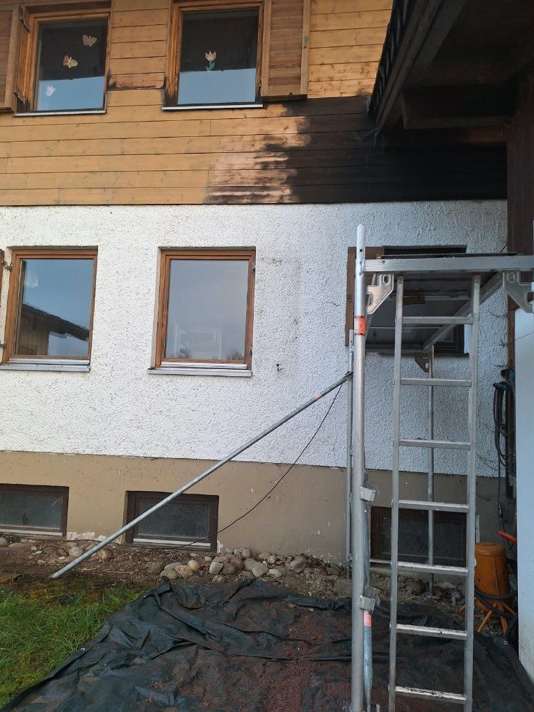 Holzschalung, der dunkle Lasurton zieht über die helle Fläche